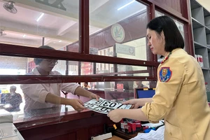 Cán bộ Phòng CSGT tỉnh Gia Lai cấp biển số xe định danh cho người dân. Ảnh: L.KIẾN