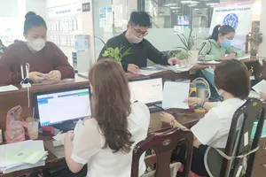 Người dân đang thực hiện các thủ tục liên quan đến BHXH ở cơ quan BHXH TP.HCM. Ảnh: NGUYỄN HIỀN