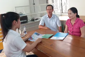 Cán bộ BHXH Việt Nam đang tư vấn về BHXH tự nguyện cho người dân. Ảnh: VIẾT LONG