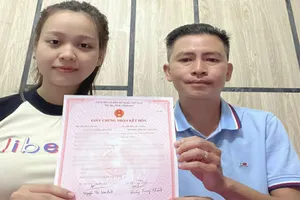 Vợ chồng anh Hoàng Trung Thành vui mừng khi nhận giấy đăng ký kết hôn. Ảnh: NH