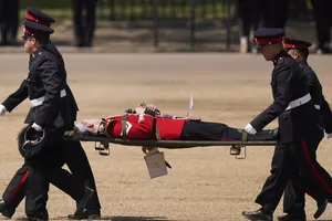 Vệ binh Anh được đưa lên cáng sau khi ngất xỉu. Ảnh: AFP