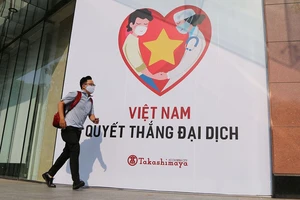 Khẩu hiệu "Việt Nam quyết thắng đại dịch" đặt trước một trung tâm thương mại ở quận 1. Ảnh: HOÀNG GIANG