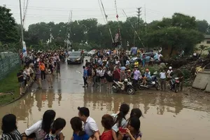 Độc nhất vô nhị: Người Hà Nội đi làm bằng xe ủi do mưa ngập