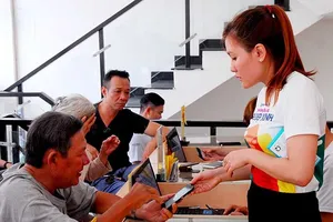 Các DN từng kêu ca sản phẩm công nghệ cao như iPhone 7, iPhone 8… vẫn phải kiểm tra chuyên ngành. Trong ảnh: Khách hàng đang mua điện thoại di động tại cửa hàng. Ảnh: HTD