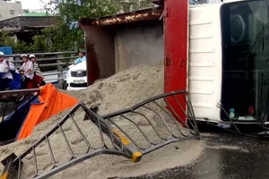 Xe chở cát bị lật trên cầu vượt ở TP.HCM