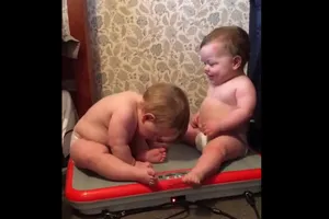 2 em bé ngồi trên máy rung lắc vui nhộn