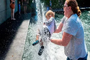 Người phụ nữ bế con ở một công viên ở thủ đô Washington, Mỹ hôm 28-6. Ảnh: AFP