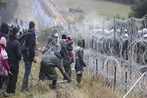 Người tị nạn cố vượt hàng rào kẽm gai ở biên giới Ba Lan. Ảnh: AP