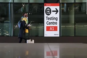 Một du khách đi vào hướng khu vực xét nghiệm ở sân bay. Ảnh: CNN