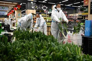 Nhân viên siêu thị và người giao hàng chuẩn bị cung cấp nhu yếu phẩm cho người dân Tây An hôm 28-12. Ảnh: XINHUA