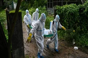 Tình nguyện viên Myanmar khiêng xác một người chết vì COVID-19 đến nghĩa trang ở TP Yangon, Myanmar. Ảnh: AFP