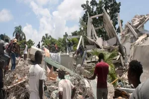 Người dân Haiti tìm kiếm nạn nhân trong đống đổ nát. Ảnh: AFP