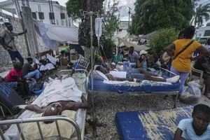 Người bị thương nằm trên gường bệnh đặt bên ngoài bệnh viện Immaculée Conception (Les Cayes, Haiti). Ảnh: AP