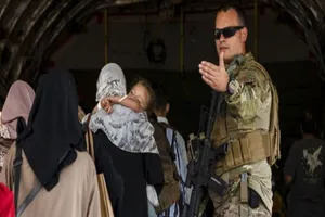 Binh sĩ Mỹ hỗ trợ người dân lên máy bay sơ tán. Ảnh: AP