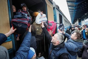 Người dân Ukraine lên tàu di cư sang các nước láng giềng. Ảnh: REUTERS