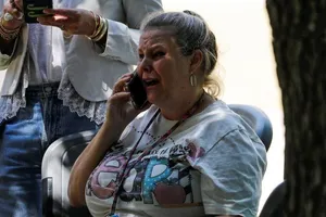 Một phụ nữ bật khóc ngay sau khi nghe tin vụ xả súng. Ảnh: REUTERS