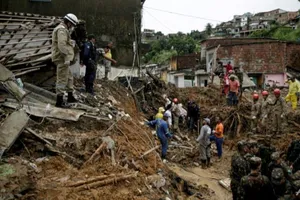 Binh lính, lực lượng cứu hỏa cùng người dân địa phương nỗ lực tìm kiếm nạn nhân của trận lở đất tại TP Recife, bang Pernambuco (Brazil) hôm 29-5. Ảnh: AFP