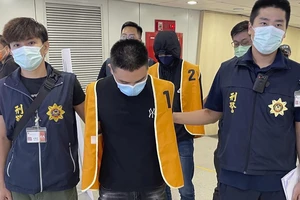 Cảnh sát Đài Loan áp giải hai nghi phạm liên quan đến các vụ lừa đảo ở Campuchia. Ảnh: AP 