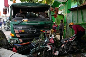 Cảnh sát dọn dẹp các mảnh vỡ sau vụ tai nạn giao thông ở thành phố Bekasi (Indonesia) ngày 31-8. Ảnh: AP