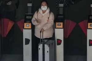 Một người phụ nữ đeo khẩu trang ra khỏi ga tàu điện ngầm ở Bắc Kinh, Trung Quốc vào ngày 13-12. Ảnh: AP 