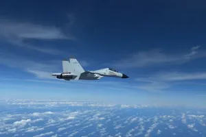 Tiêm kích J-11 của Trung Quốc áp sát máy bay trinh sát RC-135 của Mỹ trên Biển Đông ngày 21-12. Ảnh: REUTERS
