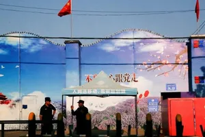 Bảo vệ trước cổng một trung tâm giáo dục kỹ năng nghề nghiệp tại Tân Cương, Trung Quốc, năm 2018. Ảnh: REUTERS