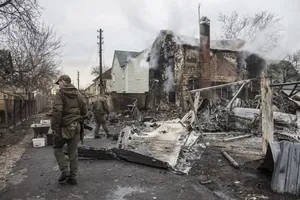 Binh sĩ Ukraine bên những mảnh vỡ của một chiếc máy bay bị bắn rơi ở Kiev, Ukraine ngày 25-2. Ảnh: AP