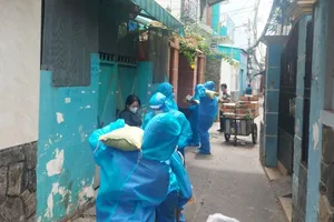 Các suất quà bao gồm thực phẩm, nhu yếu phẩm được trao tận tay cho các hộ dân trong khu phong toả ở quận Bình Thạnh. Ảnh: NGUYỄN YÊN
