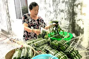 Một gia đình luôn giữ gìn truyền thống gói bánh tét dịp Tết Nguyên đán