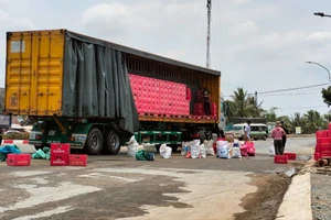 Xe container ôm cua gấp làm rơi hàng chục két bia xuống đường