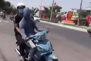 Công an làm việc với người trùm kín mặt chạy xe máy