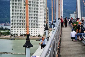 Người đàn ông ngồi 11 tiếng trên lan can cầu, dọa nhảy xuống