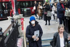 Một thanh niên mang khẩu trang xuống một trạm tàu điện ngầm ở London (Anh) ngày 13-3. Ảnh: REUTERS