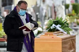 Một linh mục mang khẩu trang cầu nguyện cho một người vừa qua đời ở một lễ tang tại nghĩa trang TP Bolgare, vùng Lombardy (Ý). Ảnh: AFP
