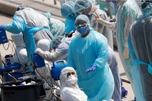 Nhân viên y tế chuẩn bị sơ tán các thủy thủ bị bệnh trên một du thuyền đậu ở cảng Miami, bang Florida (Mỹ) ngày 26-3. Ảnh: REUTERS