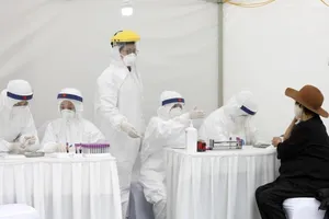 Một phụ nữ lớn tuổi được lấy mẫu xét nghiệm tại một trung tâm xét nghiệm nhanh COVID-19 ở Hà Nội tháng trước. Ảnh: EPA