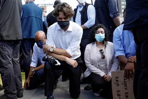Thủ tướng Canada Justin Trudeau (áo trắng) quỳ gối trong một cuộc tuần hành ở thủ đô Ottawa, bang Ontario (Canada) ngày 5-6. Ảnh: REUTERS