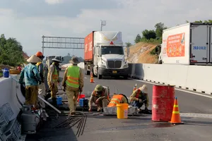 Ảnh: Công nhân làm việc giữa dòng xe cộ trên cao tốc Nha Trang - Cam Lâm