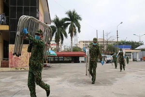 Các chiến sĩ của Bộ chỉ huy Quân sự tỉnh Hải Dương đang vận chuyển các giường bệnh. ẢNH: NGÔ ANH VĂN
