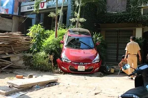Lùi xe ô tô đổ rào, gây thương tích cho hàng xóm