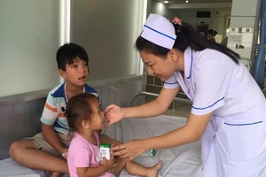 Bác sĩ vừa đỡ đẻ vừa chăm sóc 2 con giùm sản phụ