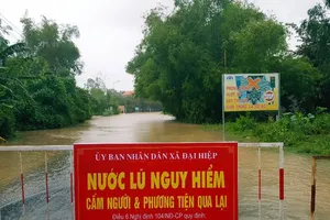 Lũ cắt đường, dân phải trả tiền qua đoạn ngập