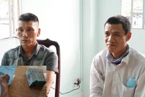 Tài xế Nguyễn Quốc An (phải) giao tiền cho người nhà bà T. Ảnh: L.A 