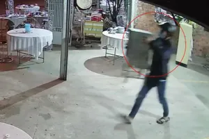 Nam thanh niên ôm thùng phúng điếu bỏ chạy. Ảnh: Cắt từ camera