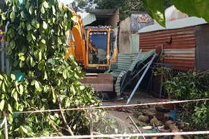 Người lái xe múc phá sập 2 căn nhà ở Bình Phước là do mâu thuẫn trong làm ăn