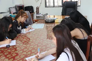 Các cô gái "đi khách" ghi lời khai tại cơ quan công an. Ảnh: LA