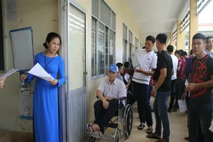 Thí sinh ngồi xe lăn đến làm thủ tục thi