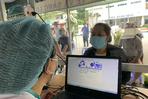 Nhân viên y tế hỗ trợ người dân khai báo y tế. Ảnh: HL