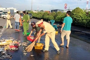 CSGT quận 12 cùng người dân thu gom cá giúp chủ xe gặp nạn 