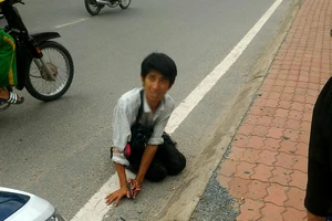 Một thanh niên giả tàn tật lết bán vé số